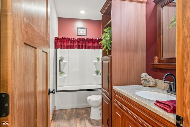 full bathroom with shower / bathtub combination, vanity, wood-type flooring, and toilet