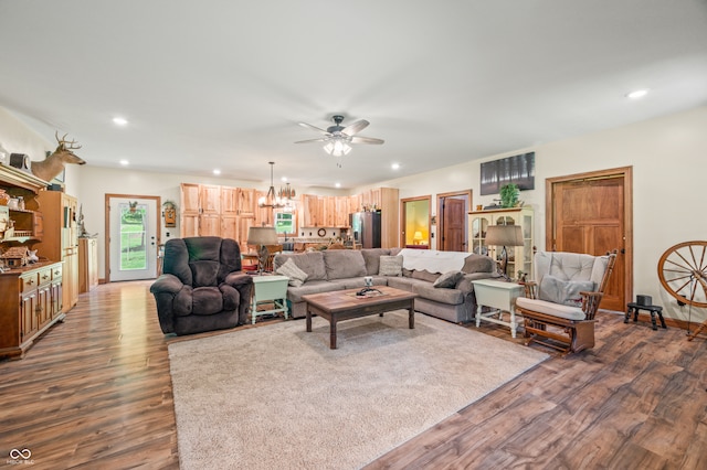 living room featuring hardwood / wood-style flooring and ceiling fan with notable chandelier