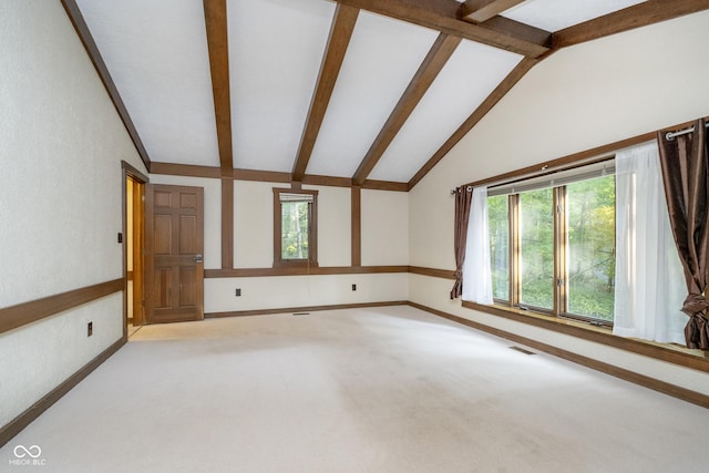 carpeted spare room with lofted ceiling with beams and baseboards