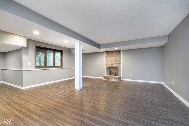 unfurnished living room featuring a fireplace, dark wood finished floors, and baseboards