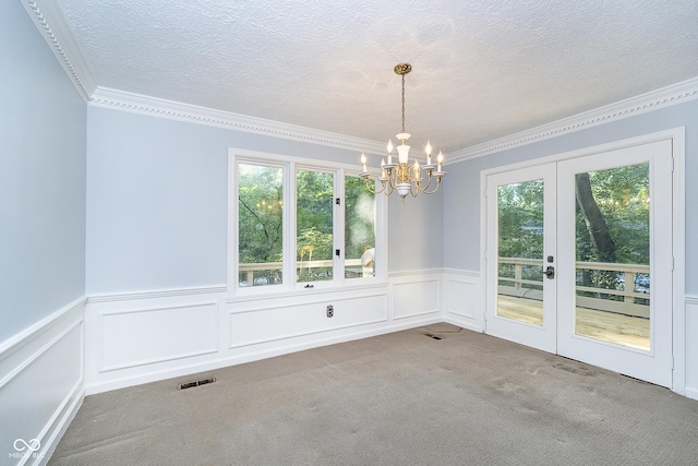 unfurnished dining area featuring plenty of natural light, carpet, visible vents, and a textured ceiling