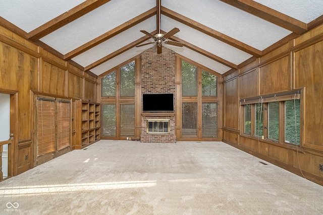 unfurnished living room with carpet, wooden walls, high vaulted ceiling, and beamed ceiling