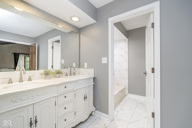 bathroom featuring marble finish floor, a sink, baseboards, and double vanity