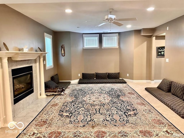 living room featuring light tile patterned flooring, ceiling fan, a fireplace, and a wealth of natural light