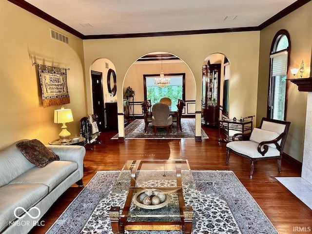 living room with an inviting chandelier, ornamental molding, and dark hardwood / wood-style floors