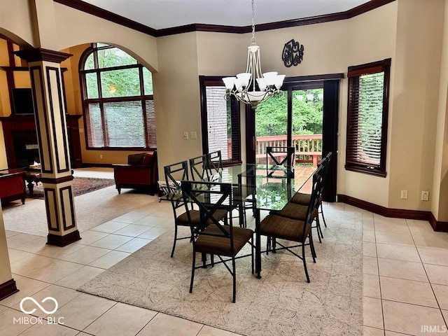 tiled dining space featuring an inviting chandelier, crown molding, and ornate columns