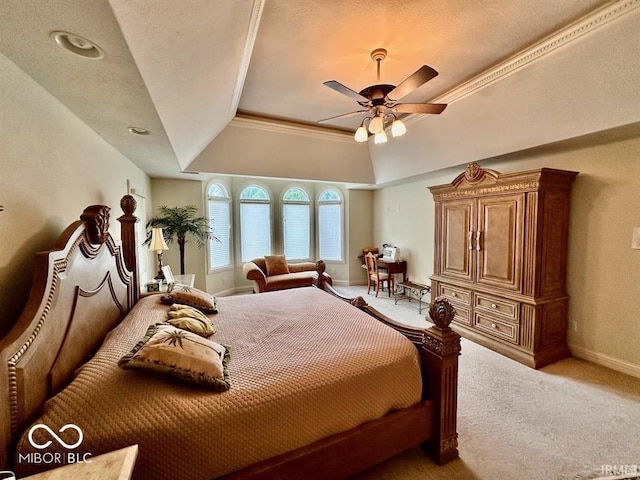 carpeted bedroom with a raised ceiling, ornamental molding, and ceiling fan