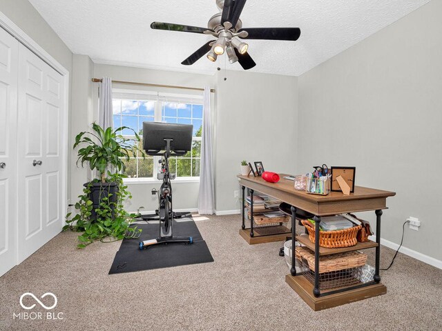 home office featuring carpet floors, a textured ceiling, and ceiling fan