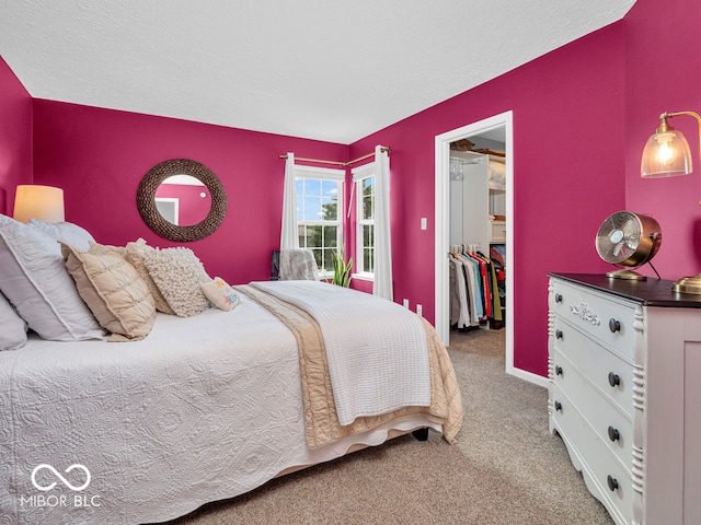 bedroom featuring light carpet, a closet, and a walk in closet