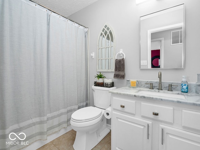 bathroom featuring tile patterned flooring, toilet, vanity, and a textured ceiling