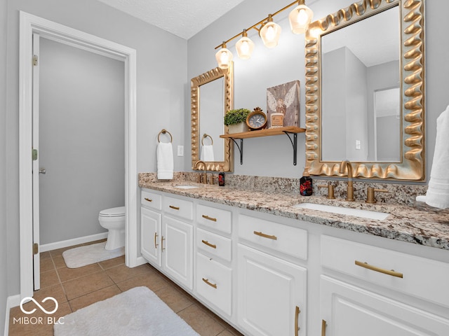 bathroom with tile patterned flooring, dual vanity, toilet, and a textured ceiling