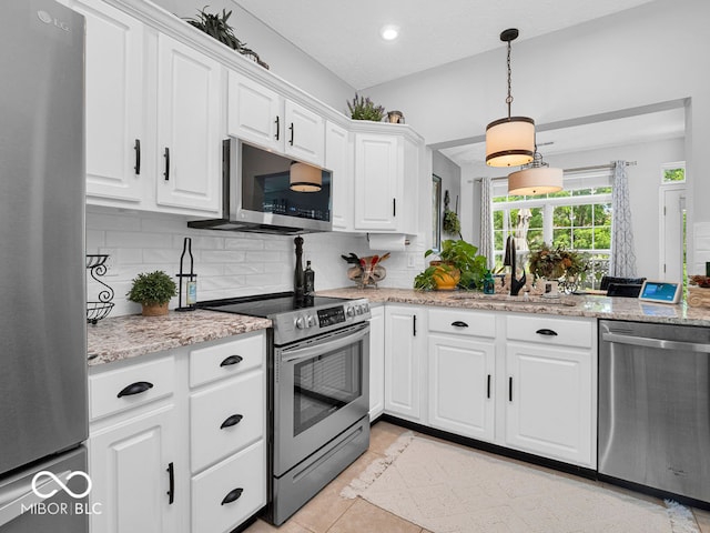 kitchen with white cabinetry, tasteful backsplash, stainless steel appliances, sink, and light tile patterned floors