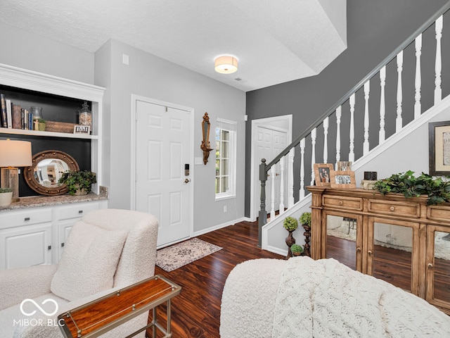 entrance foyer with a textured ceiling and dark hardwood / wood-style floors