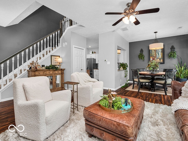 living room with a textured ceiling, hardwood / wood-style flooring, and ceiling fan