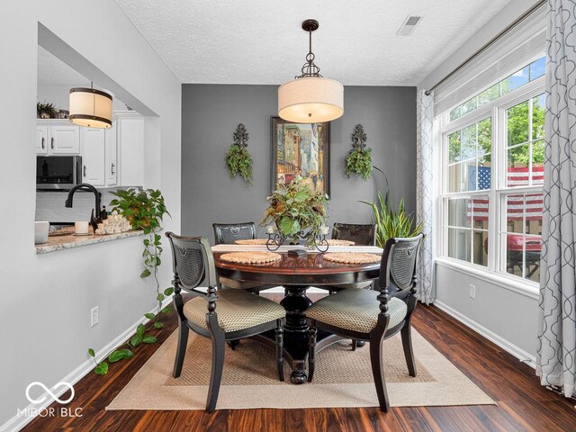 dining room featuring a textured ceiling and dark wood-type flooring