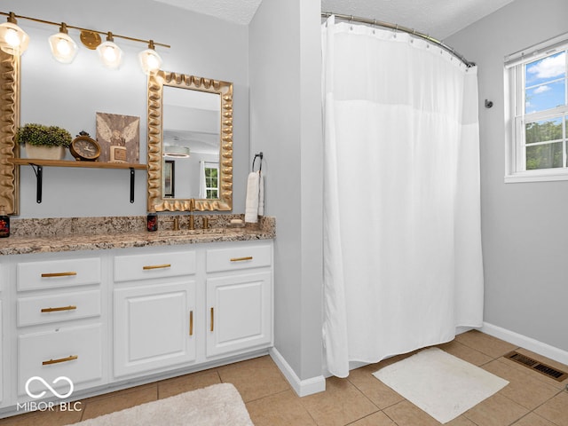 bathroom with vanity, tile patterned flooring, and a textured ceiling