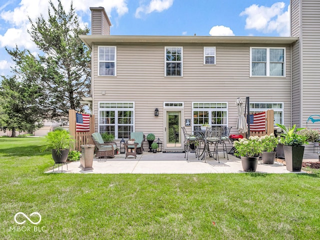 rear view of property featuring a patio and a lawn