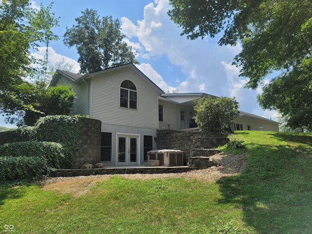 rear view of house featuring french doors, central AC unit, and a lawn