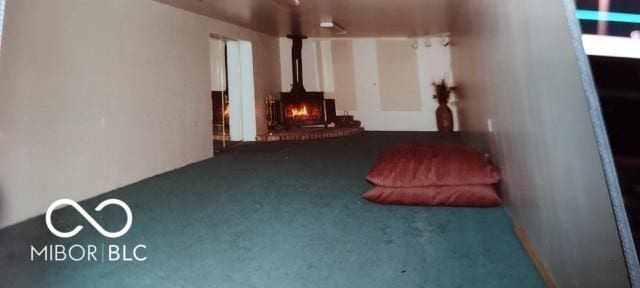 interior space featuring dark colored carpet and a wood stove