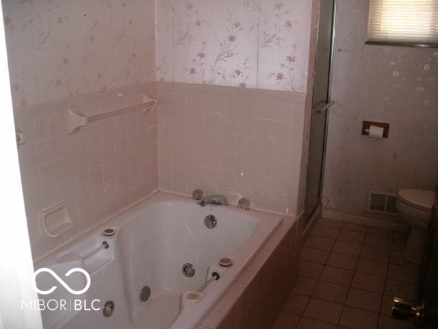 bathroom with a tub, tile patterned floors, and toilet