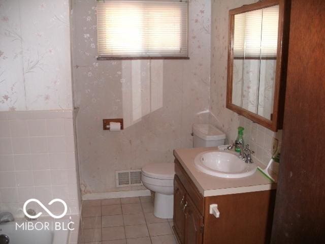 bathroom featuring vanity, tile patterned floors, toilet, and a healthy amount of sunlight