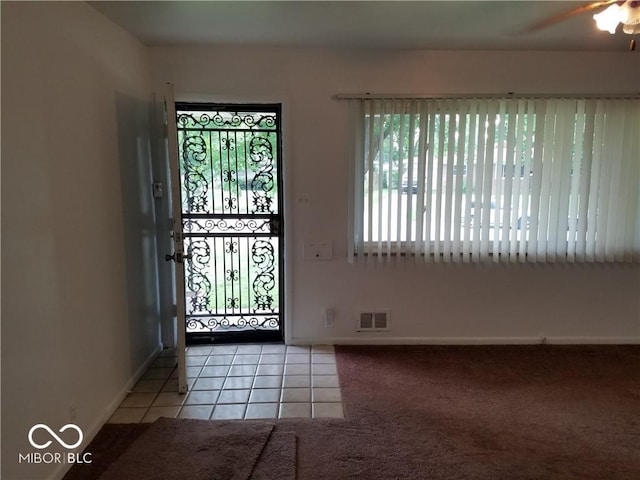 foyer with light tile patterned floors and ceiling fan