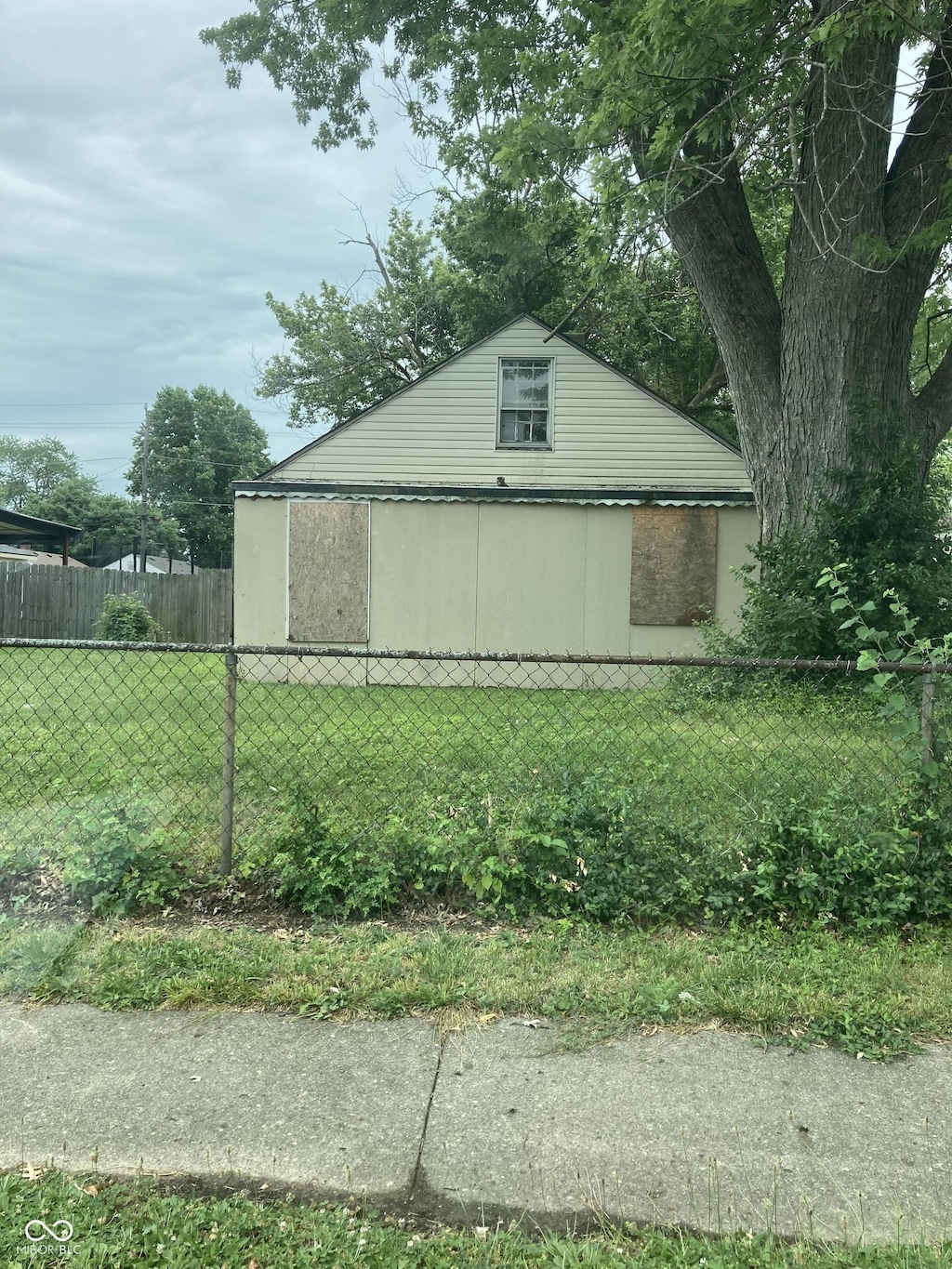 view of side of property featuring fence and a yard