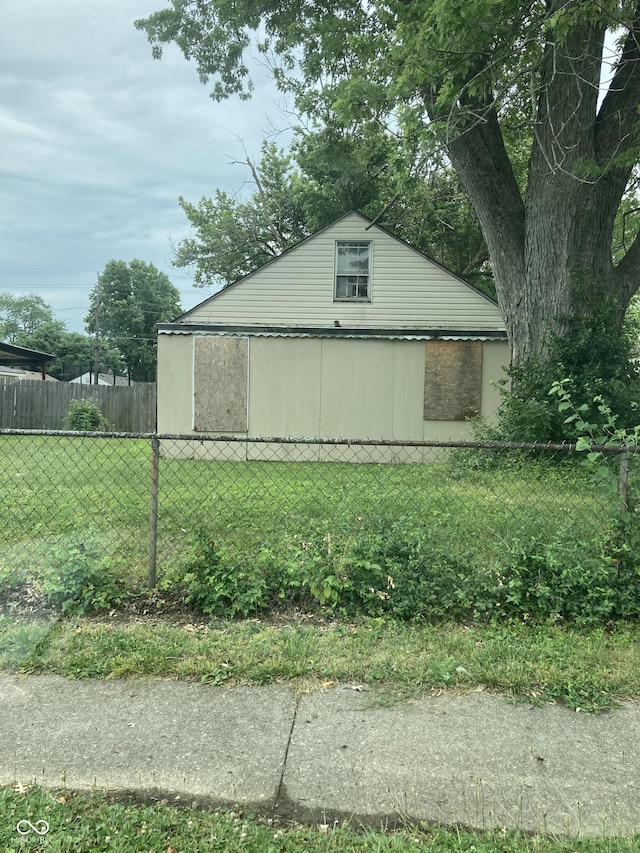 view of side of property featuring fence and a yard