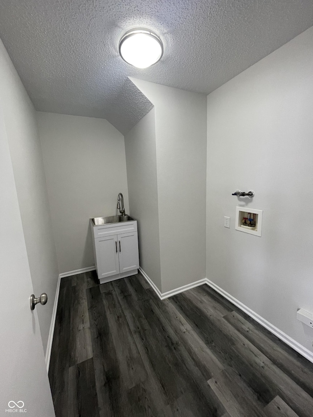 clothes washing area with sink, cabinets, a textured ceiling, dark hardwood / wood-style floors, and hookup for a washing machine