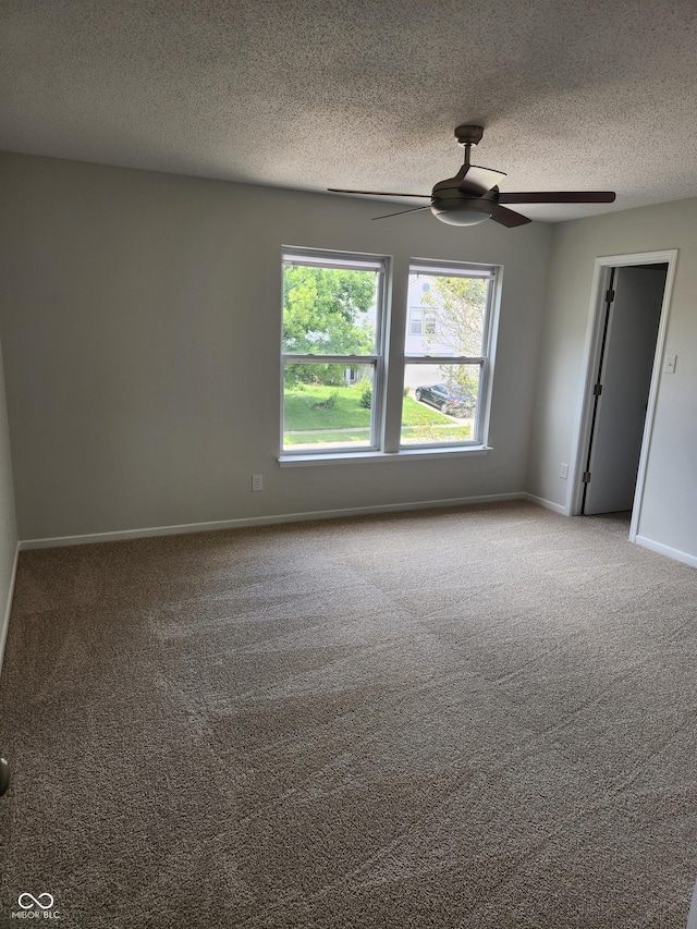 carpeted spare room with ceiling fan and a textured ceiling