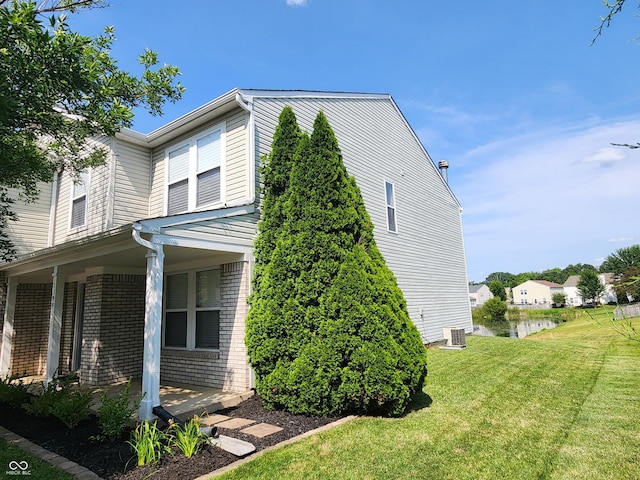 view of side of home featuring central AC unit, a lawn, and a porch