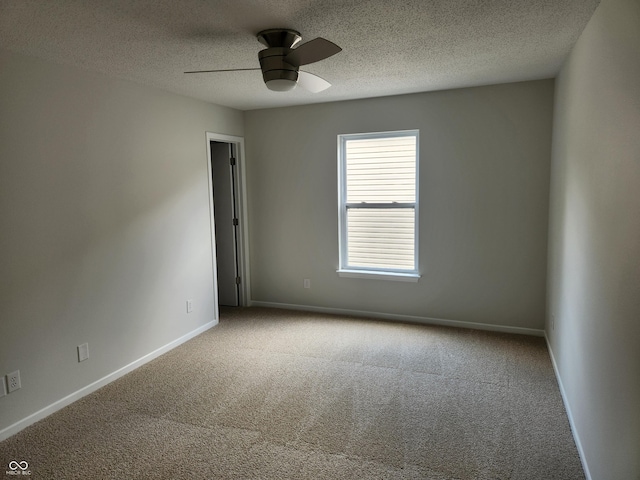 carpeted spare room featuring a textured ceiling and ceiling fan