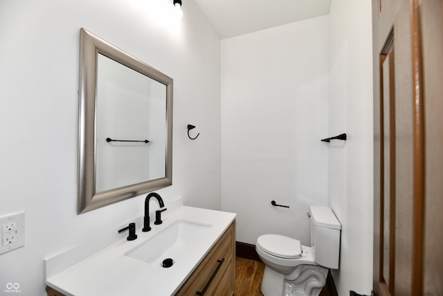 bathroom with vanity, toilet, and wood-type flooring