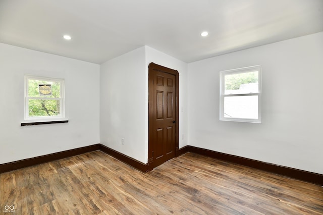 spare room featuring hardwood / wood-style flooring and plenty of natural light