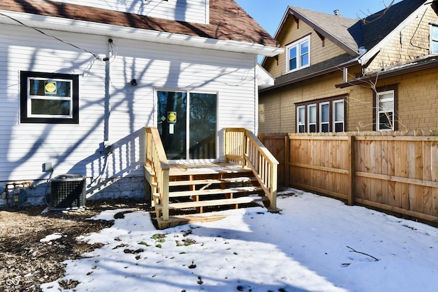 snow covered rear of property with central AC unit