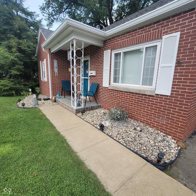 view of exterior entry with a lawn