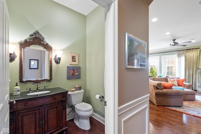 bathroom featuring ceiling fan, vanity, toilet, and hardwood / wood-style floors