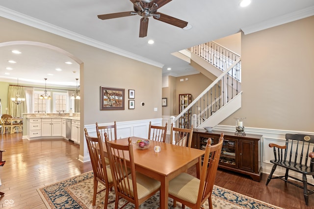 dining space with ornamental molding, dark hardwood / wood-style floors, and ceiling fan with notable chandelier