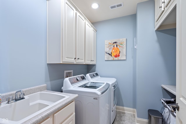 laundry room with cabinets, light tile patterned floors, sink, and washing machine and clothes dryer