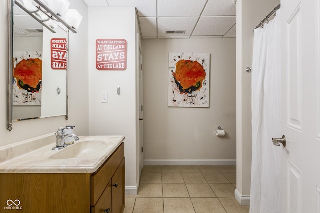 bathroom featuring vanity, tile patterned flooring, and a drop ceiling