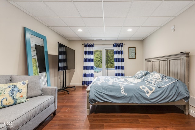 bedroom with dark wood-type flooring and a paneled ceiling