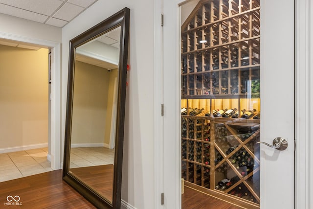 wine cellar with a drop ceiling and hardwood / wood-style floors