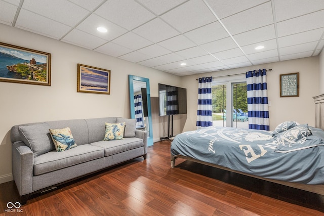 bedroom featuring a drop ceiling and dark hardwood / wood-style flooring