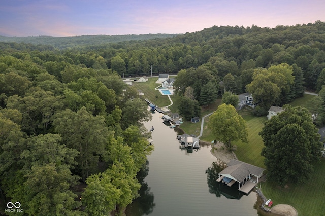 aerial view at dusk featuring a water view