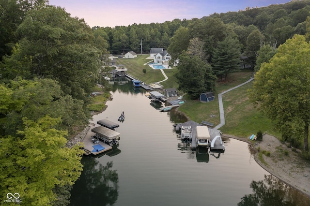 aerial view at dusk featuring a water view