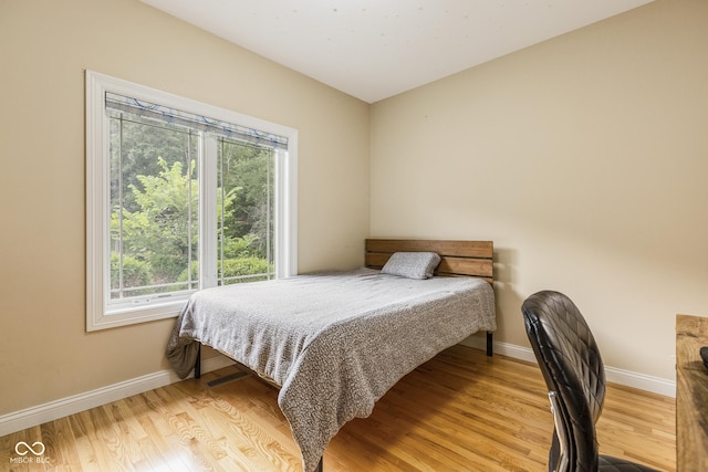 bedroom with multiple windows and light wood-type flooring