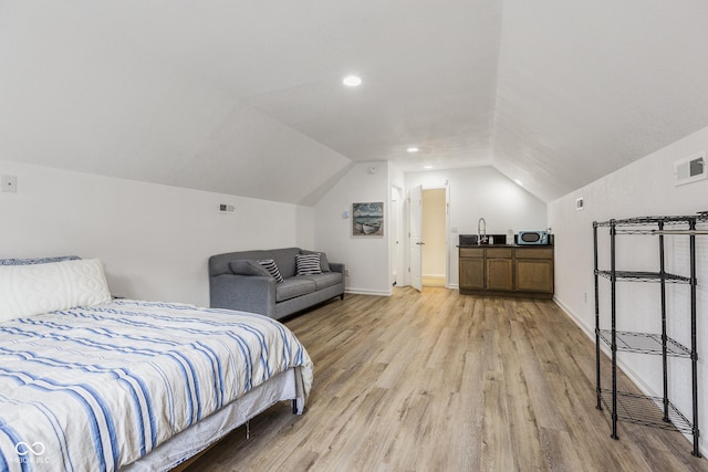 bedroom featuring lofted ceiling and light hardwood / wood-style flooring