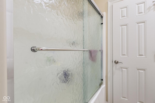 bathroom with combined bath / shower with glass door