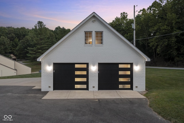 view of front of property with a garage, an outdoor structure, and a lawn