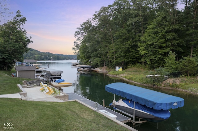 view of dock with a yard and a water view